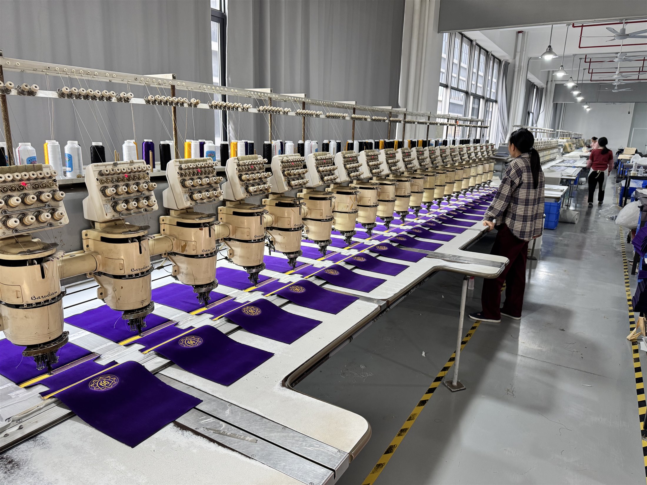 Embroidery production line applying logos to custom fabric bags